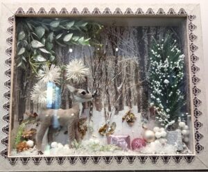 A winter-themed artwork displayed on an easel, featuring a snowy landscape, a glittering silver snowflake, and a sleigh filled with presents. White berries, green leaves, and floral accents frame the piece, adding a festive touch."Let me know if you’d like any further refinements! 